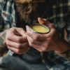 A bearded man applies Lovebee's natural beard balm