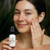 A young woman applies Lovebee's natural Hyaluronic Acid Serum to her face