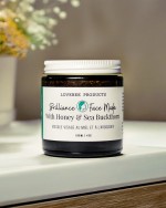 Face mask jar rests on a countertop with flowers blurred in thebackground