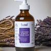 A natural lavender & honey liquid hand soap with a pump surrounded by dried lavender